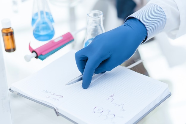 Close up. female scientist writing research results in a notebook. science and health.