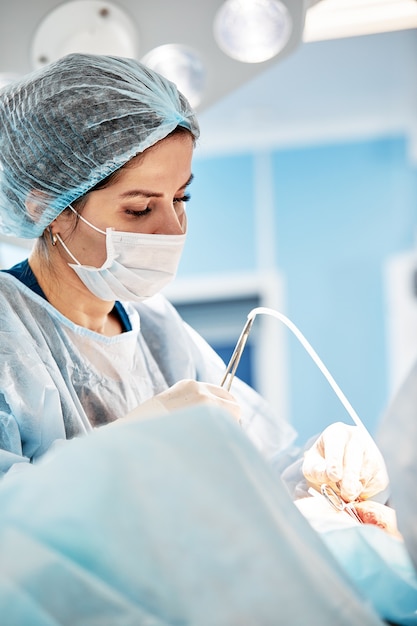 Close-up of a female surgeon in an operating room, a doctor with a tense expression on his face, in an operating room.