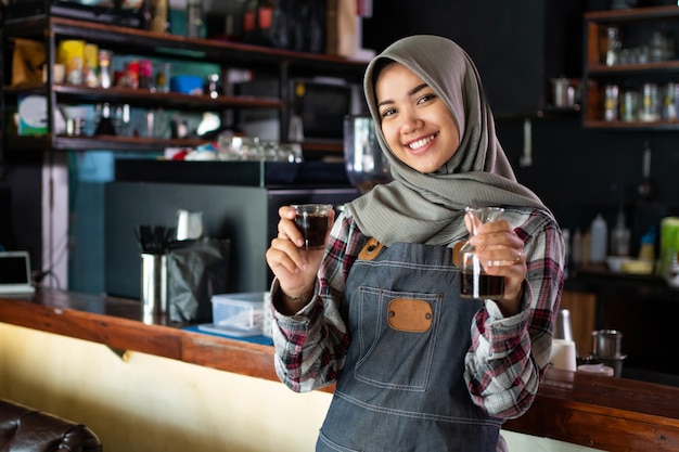 Close up of female waitress smiling hold a cup of coffee before serving to the customer