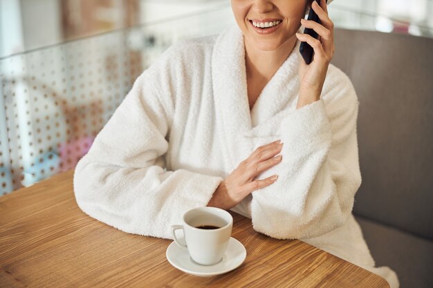 Close up on a female with a happy smile sitting at the table in a beauty salon