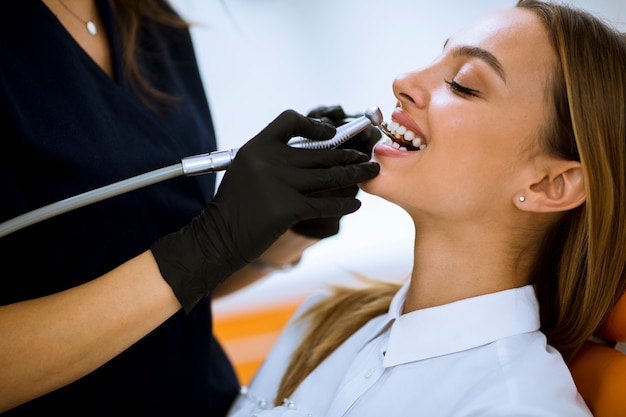 Primo piano della femmina con la bocca aperta durante il controllo orale dal dentista
