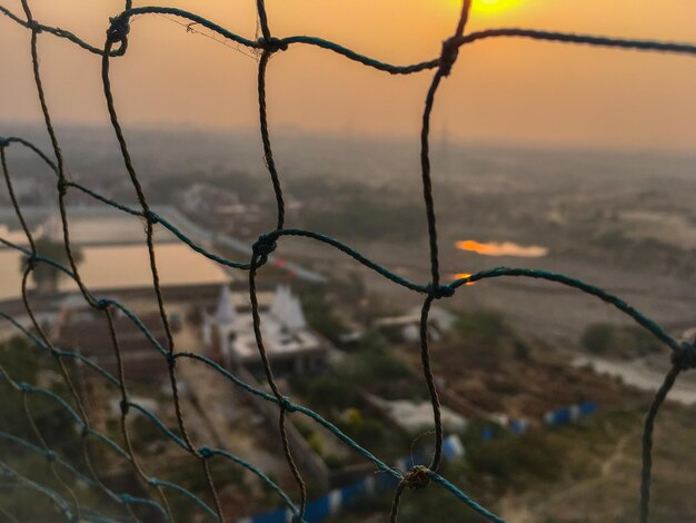 Foto close-up di una recinzione contro il cielo al tramonto