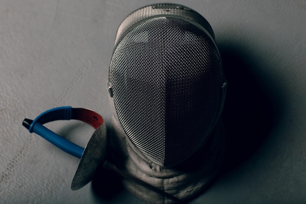 Photo close-up of fencing mask and sword