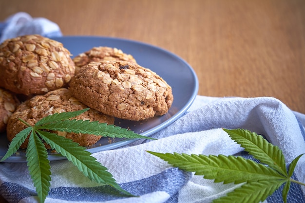 Photo close-up of a few oatmeal pot cookies on a gray plate on a striped towel on a light wooden surface.