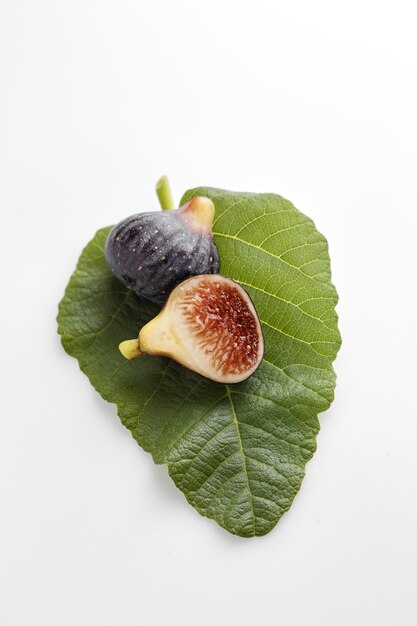 Photo close-up of fig with leaf on white background