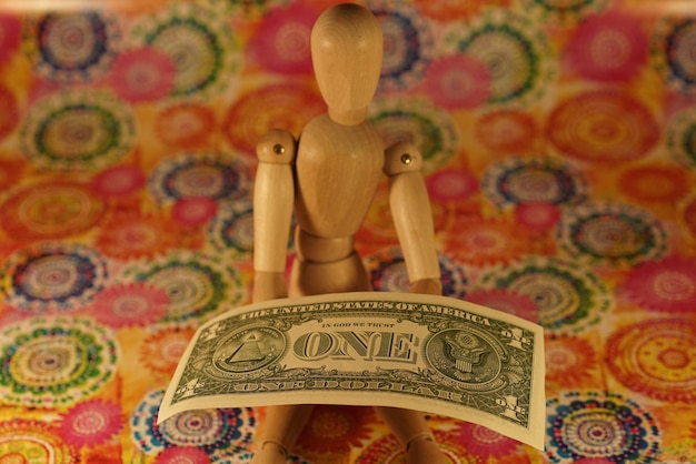 Photo close-up of figurine with paper currency on floor