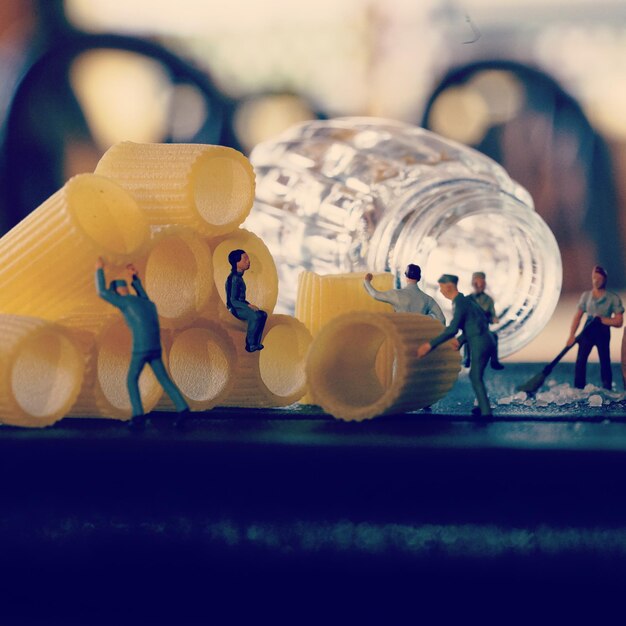 Photo close-up of figurines with bottle and food on table