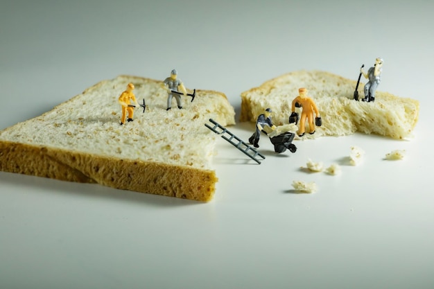 Close-up of figurines with bread over white background