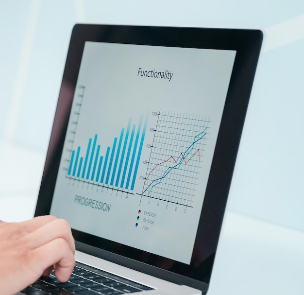 Close up financial chart on the laptop screen people and technology