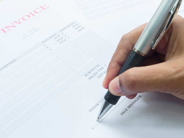 Close up fingers  holding a pen to sign on  document