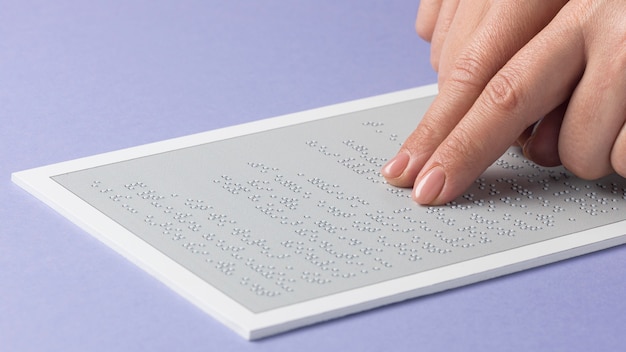 Close-up fingers reading braille document