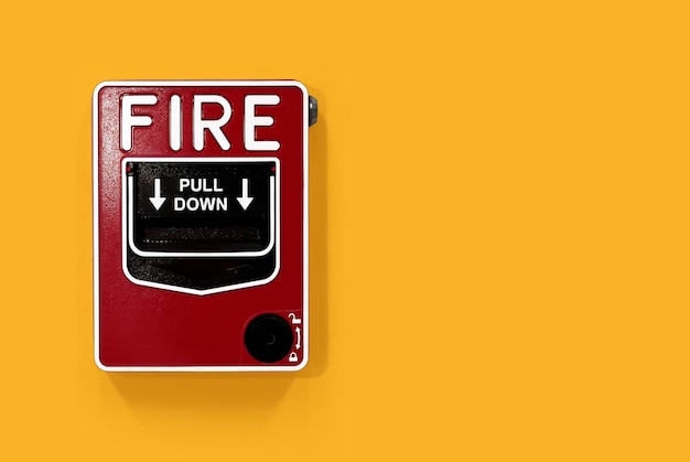 Photo close-up of fire alarm on yellow wall