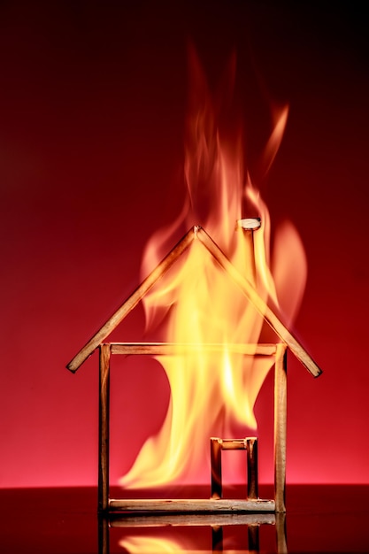 Photo close-up of fire on house toy against red background