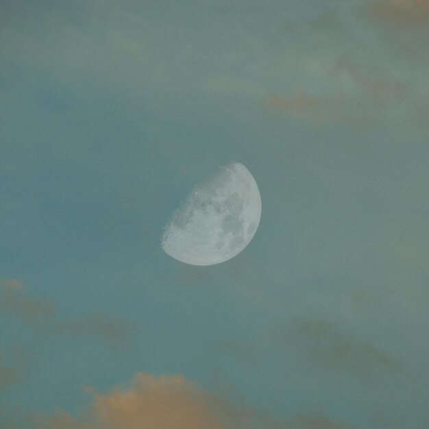 구름이 가득한 하늘 에 있는 첫 번째 사분의 달 의 클로즈업