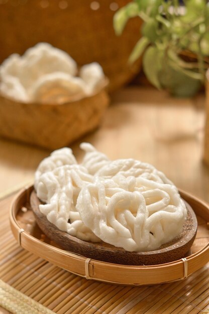 Photo close-up of fish crackers in bamboo basket on table