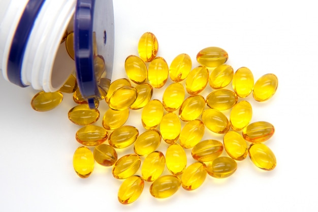 Close up fish oil capsules on white background. Many gel capsules of vitamin D3 2000 IU on white background.