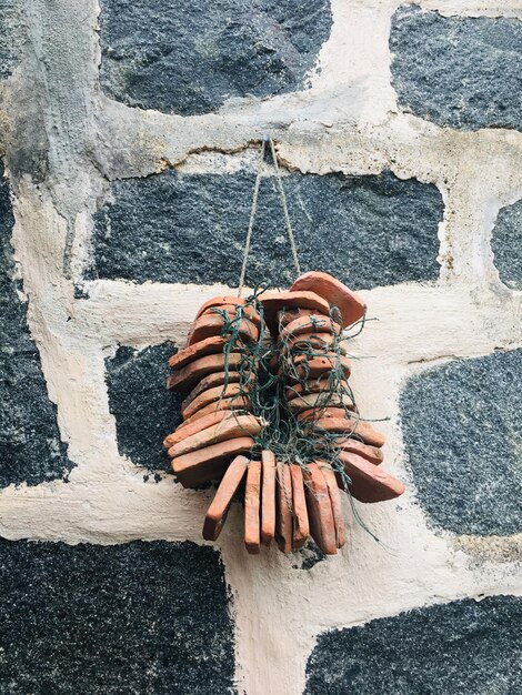 Photo close-up of fishing equipment hanging on stone wall