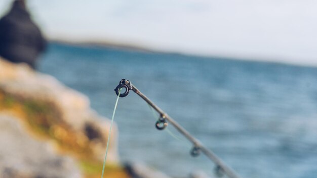 Foto prossimo piano della canna da pesca contro il lago