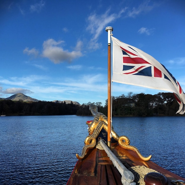 Close-up of flag against calm blue lake