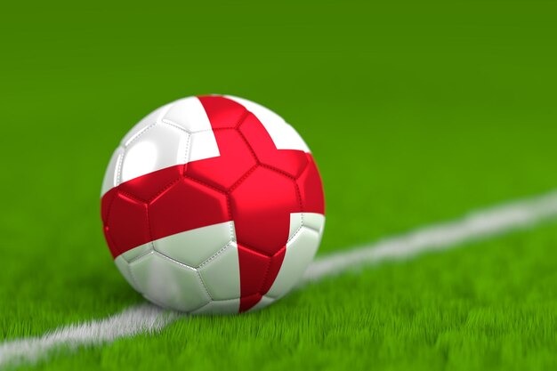 芝生のプレーフィールドに旗を塗ったサッカーボールのクローズアップ