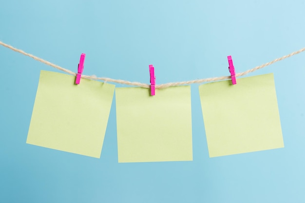 Close-up of flags hanging on rope against blue background