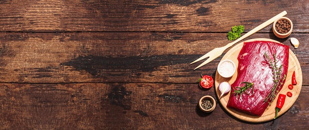 Photo close up of flank steak with traditional spices and herbs fresh raw meat cut old wooden background flat lay banner format