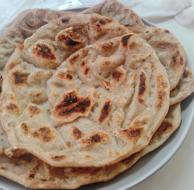 Close up of flat slices of baked roti bread on white background