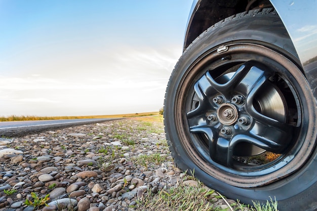 Close up of flat tire on a car on gravel road.