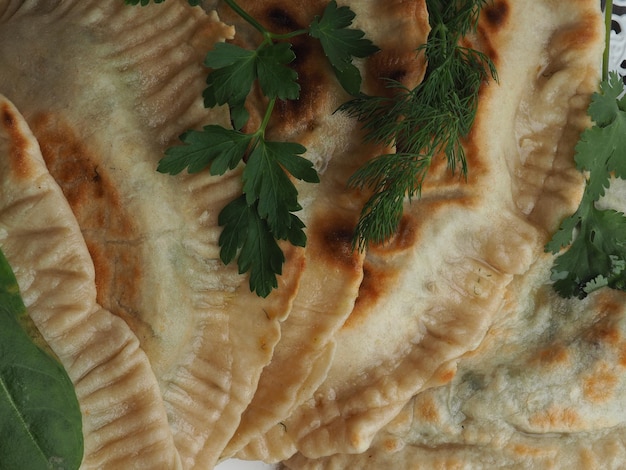 A close up of a flatbread with a sprig of parsley on it