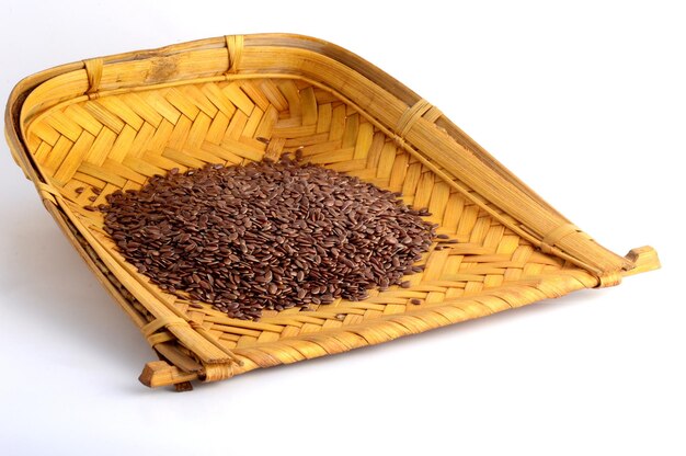 Photo close up of flax seeds in wooden basket on white background