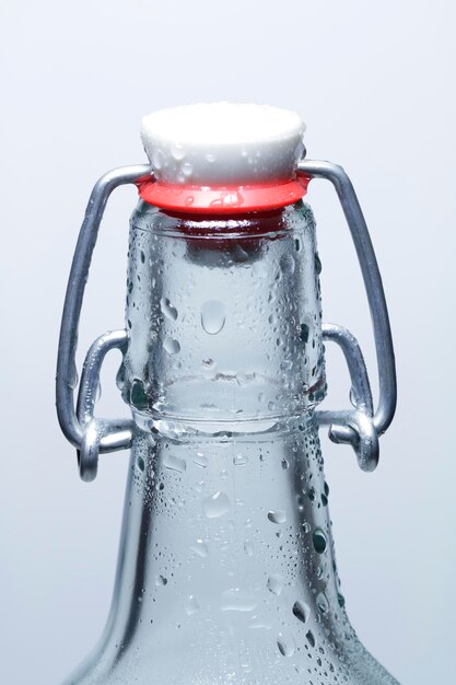 Close-up of flip-top bottle against white background