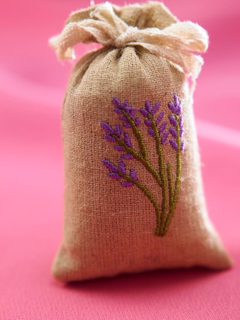 Photo close-up of floral pattern on jute sack over pink textile