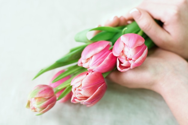 Close-up florist with flowers. Florist holding blooming bouquet of rose tulips. Flowershop concept.