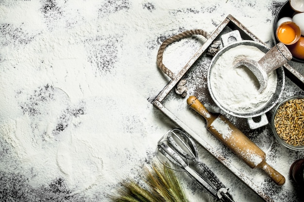 Close up on flour with eggs and rolling pin