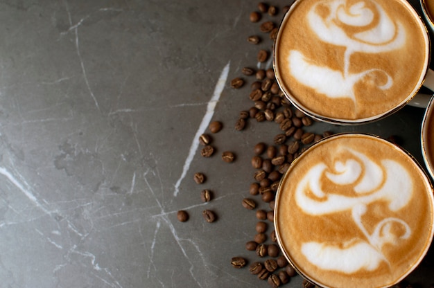 Close-up of a flower drawing on coffee, latte art on a background of coffee beans on a table