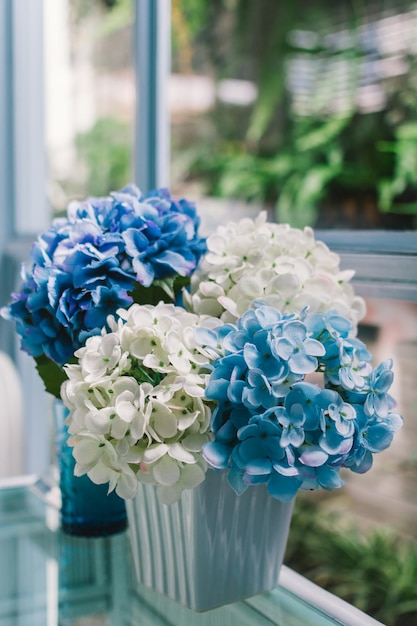 Foto close-up di vasi di fiori contro la finestra