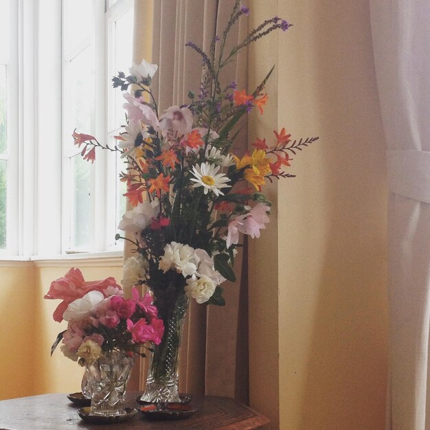 Close-up of flower vase against window