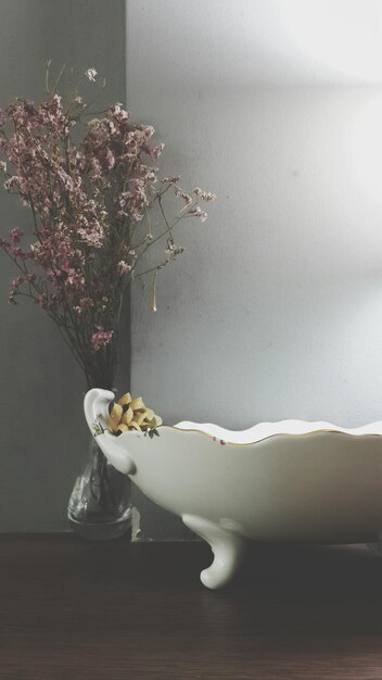 Photo close-up of flower vase on table against wall