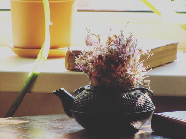 Close-up of flowers in teapot on table