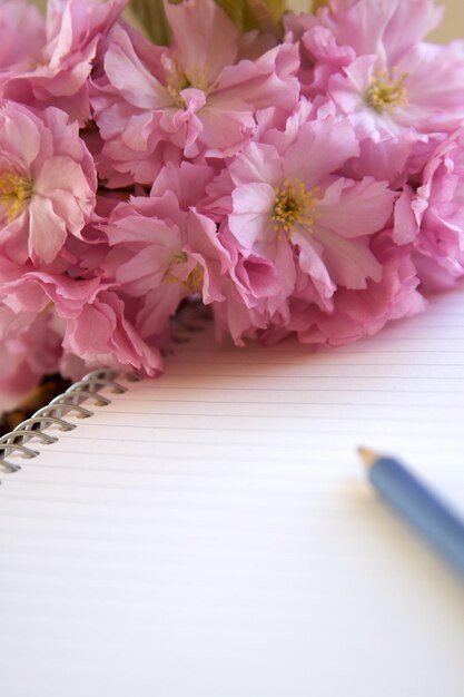 Photo close-up of flowers with book and pen on table