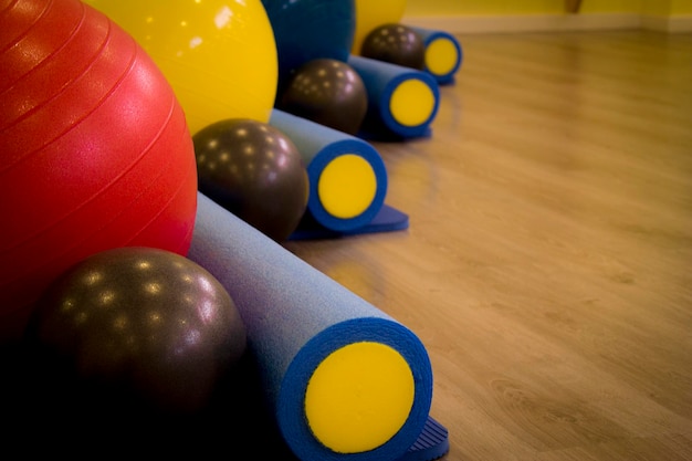 Photo close-up of foam rollers and fitness balls at gym