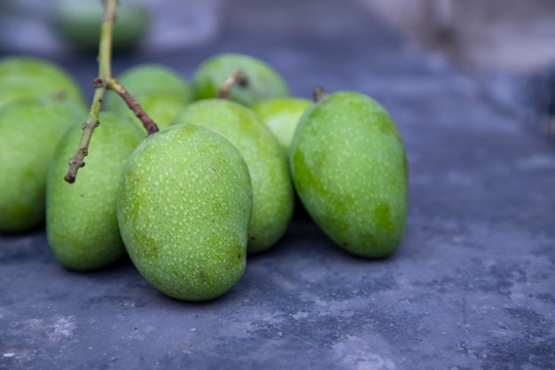 Close-up focus van wat verse rauwe groene mango op de betonnen vloer