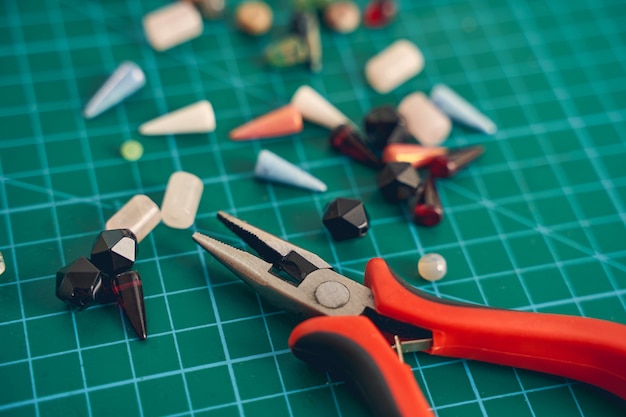 Close up focused photo of workshop while detail of jewelry lying near the tools