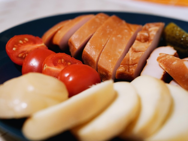 Photo close up on food -meat cheese and vegetables on a plate