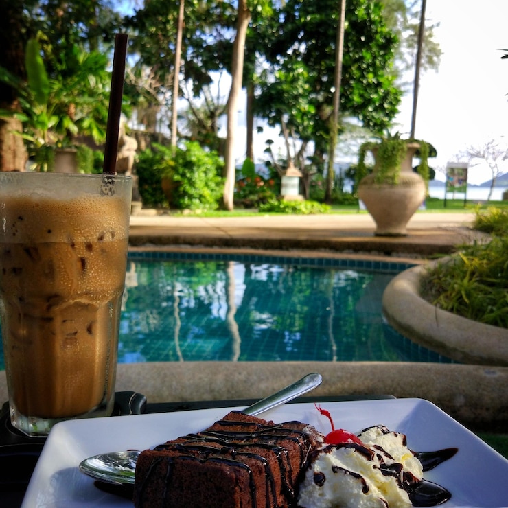 Photo close-up of food on table by swimming pool