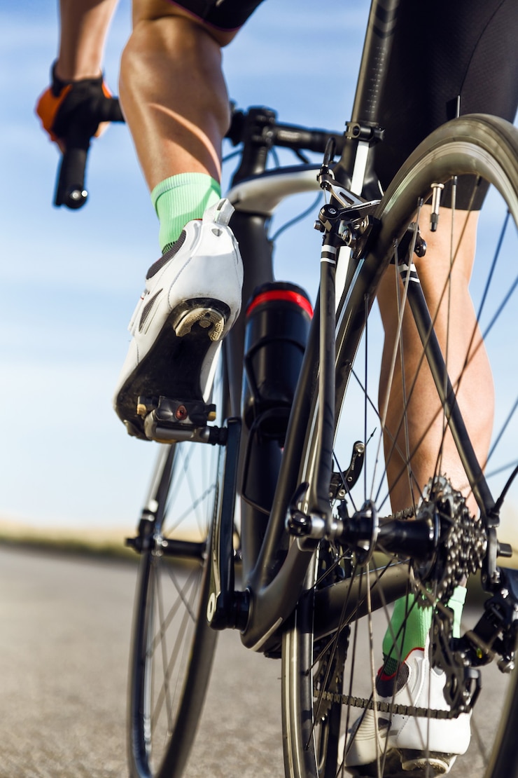 Photo close-up of the foot of a young man cycling on the road.