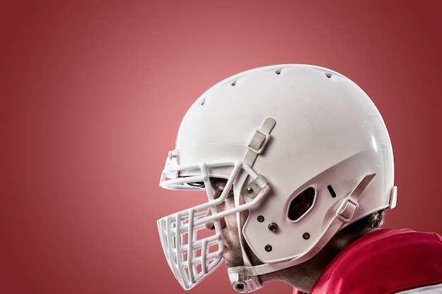 Close up of a Football Player with a red uniform on a red wall