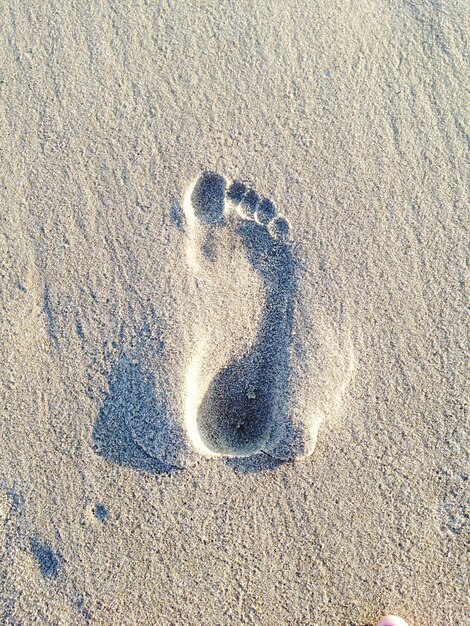 Photo close-up of footprint in sand at beach