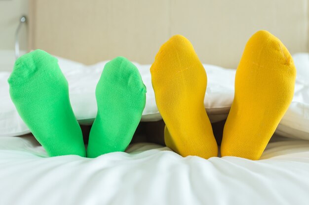 Close up foots of family with color sock on the bed