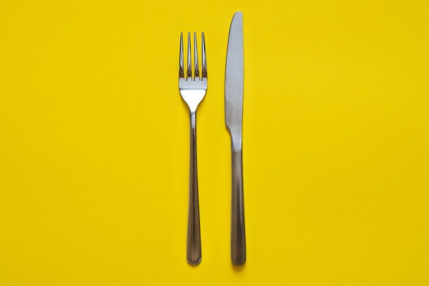 Close-up of fork over yellow background